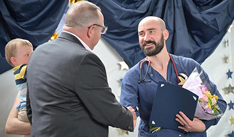 Casen Lange shakes a man's hand while receiving an award
