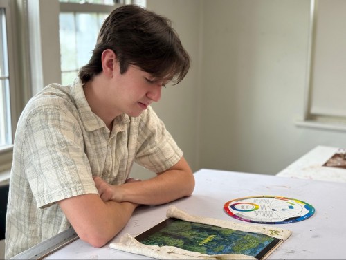 Eliott looks down at art